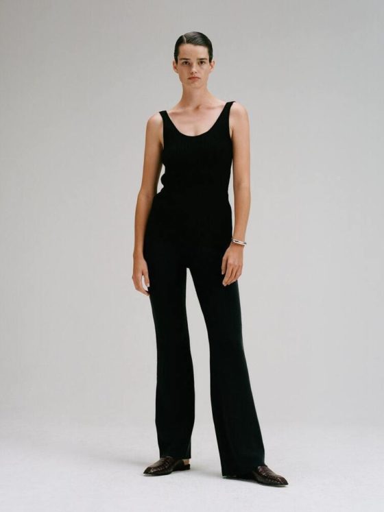 CAES model wearing a black tank top and black trousers