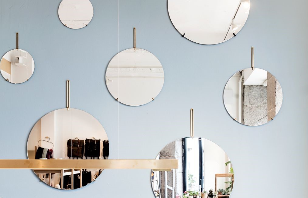 Hanging mirrors on a light blue wall