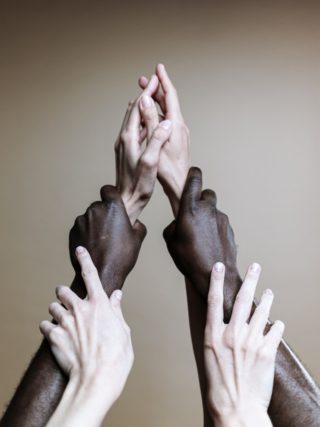 Diversity. The hands of three people of different color are holding to each other