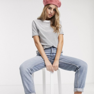 Model sits in Asos clothing with beret