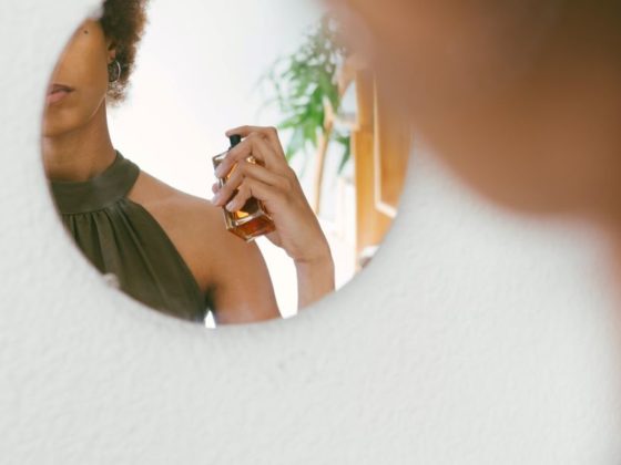 Woman spritzing herself with perfume