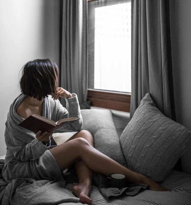 woman on couch reading a book